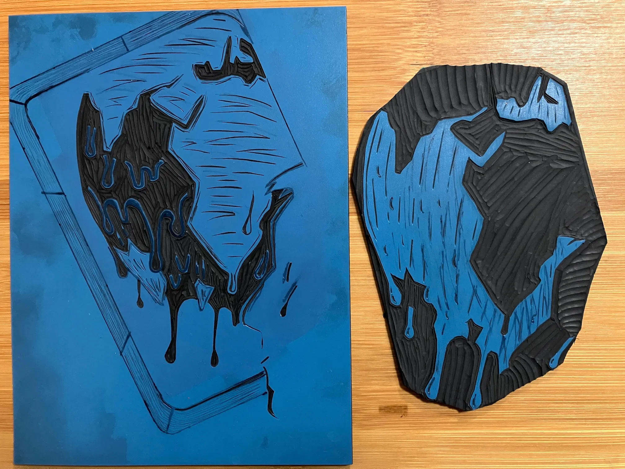 Two vinyl plates into which the black and blue ink layers for the A Grand Oasis print have been carved.