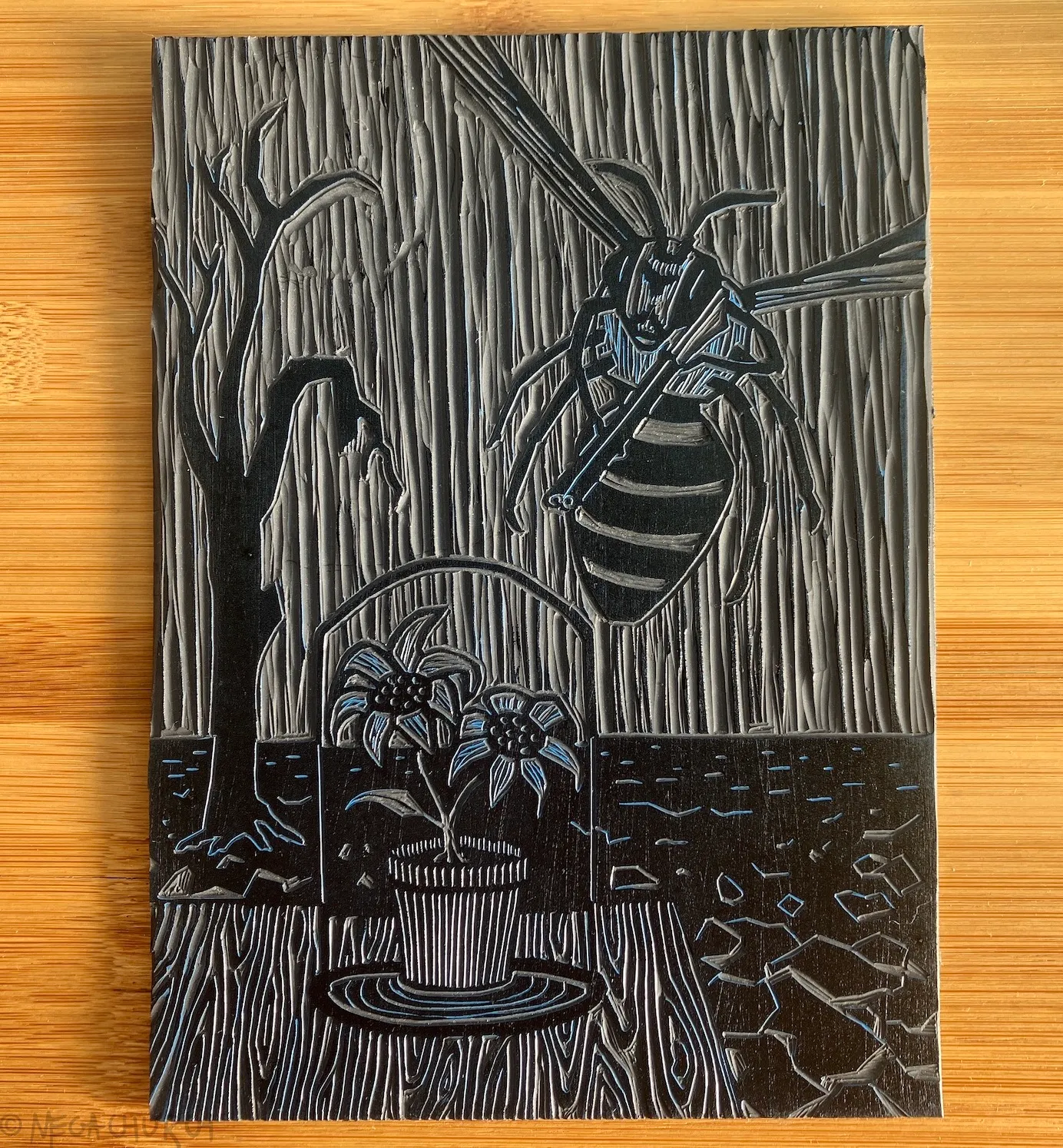 A vinyl plate into which the Bee Angry print has been carved, alongside a small Japanese cutting tool.